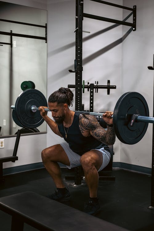 Free A Tattooed Man Lifting Barbell Stock Photo